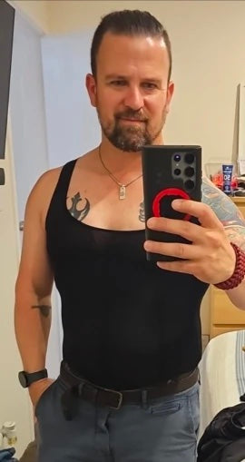 homme tatoué portant le Débardeur Allure noir, photo au miroir